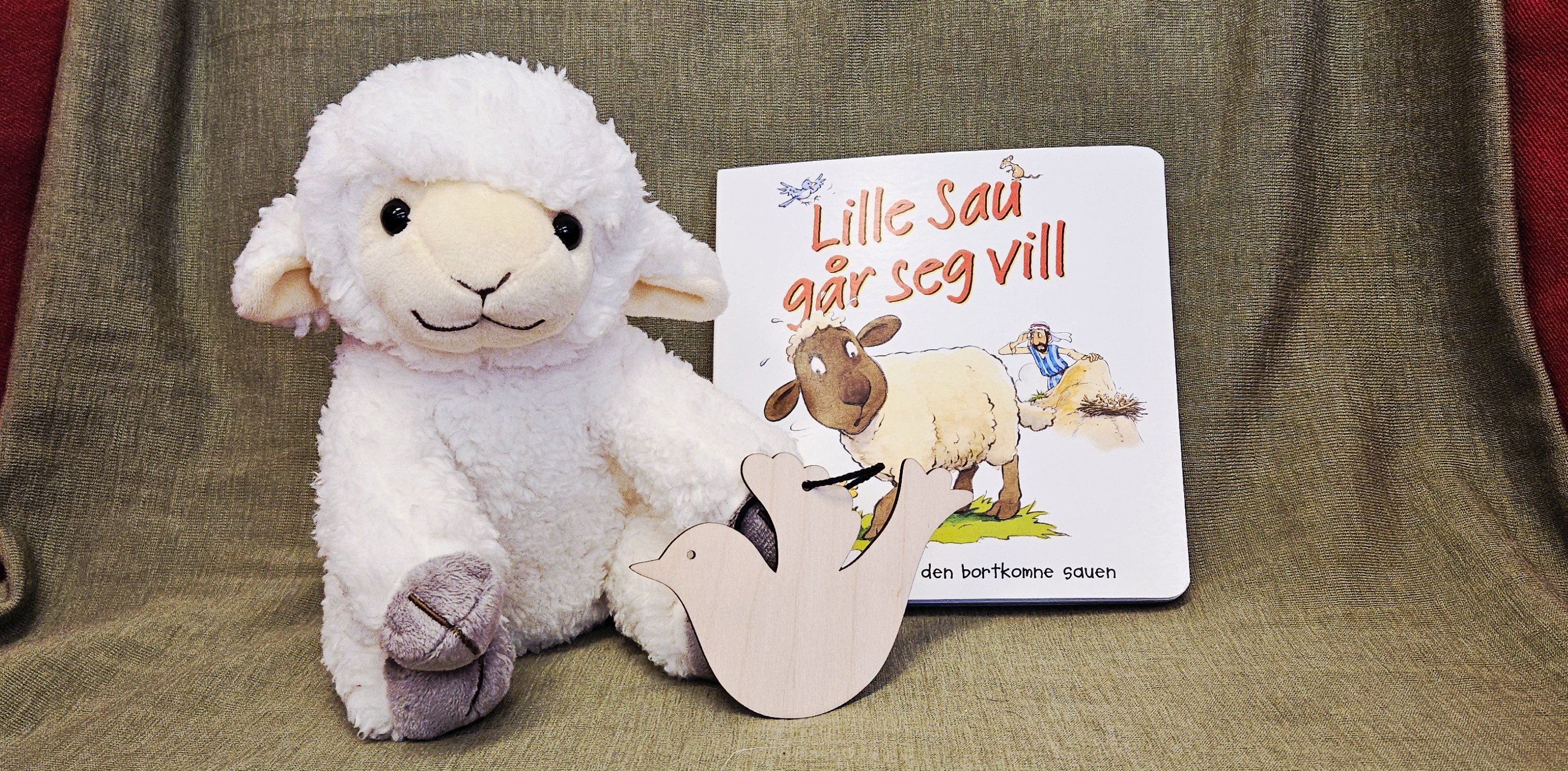 Bilde av lammet Krølle, en bok og en dåpsdue