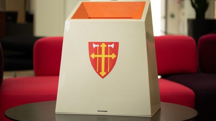 Stemmeurne med bilde av våpenskjoldet til Den norske kirke, Olavsmerket. 