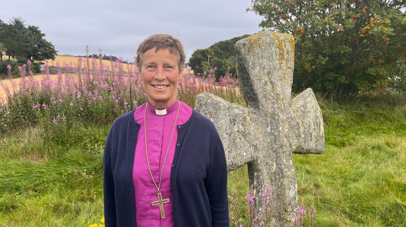 Biskop Anne Lise Ådnøy ved steinkorsene på Tjora, et talende vitnesbyrd om tidlig kristen påvirkning.