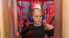 Foto: Sven-Erling Brusletto / Den norske kirke. Foto av jente som går med hørselvern og har sett på kirkeklokken i kirketårnet