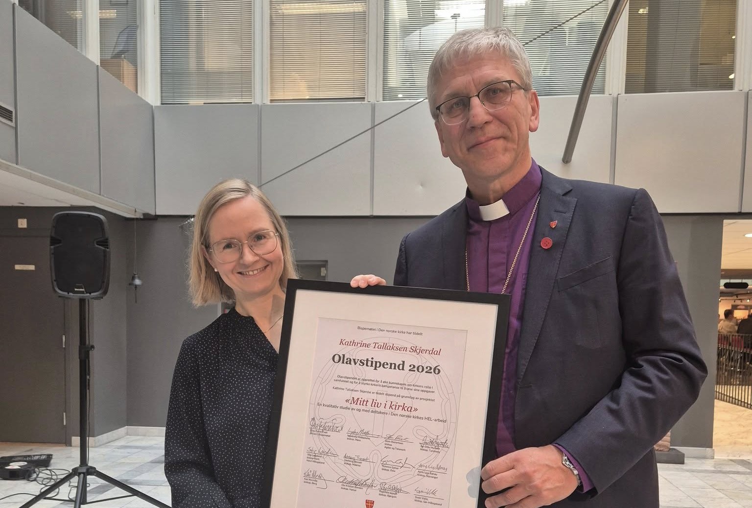 Katrine Tallaksen Skjerdal fikk stipendet overlevert av preses Olav Fykse Tveit i Kirkens hus