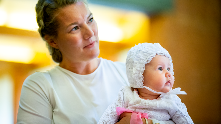 Mor og dåpsbarn med dåpslue og kjole. Foto: Bo Mathisen