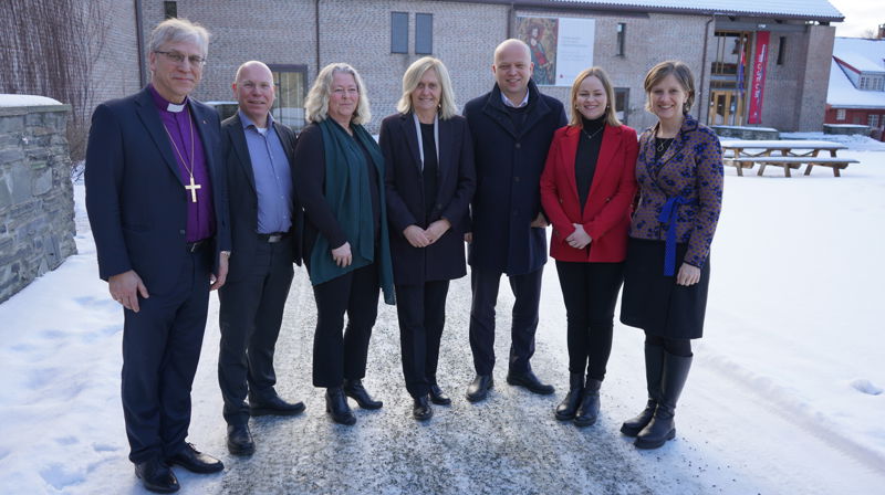 Representanter fra programstyret og regjeringen utenfor Øysteinsalen i Trondheim. Fra venstre: Preses Olav Fykse Tveit, Jan Rune Fagermoen (assisterende direktør i Kirkerådet), Turid Kolstadløkken (avdelingsdirektør i Riksantikvaren), Marit Halvorsen Haugsnæs (administrerende direktør i KA), Trygve Slagsvold Vedum (finansminister), Ragnhild Sjoner Syrstad (statssekretær i klima- og miljødepartementet) og Kjersti Toppe (barne- og familieminister). Foto: KA.