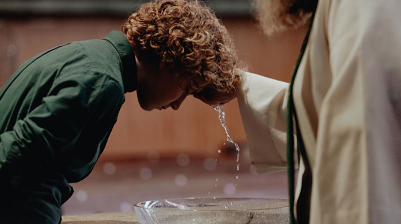 Ung gutt blir døpt. Alle kan bli døpt i Den norske kirke.