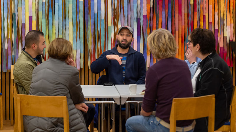 En gruppe mennesker sitter i ring i kirken og snakker sammen