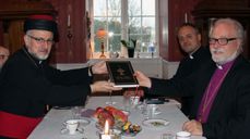 Den assyriske biskopen Mar Odisho Oraham overrekker en bibel på arameisk til biskop Atle Sommerfeldt.