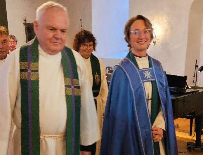 Biskop Kari og prost Espen på vei ut fra visitasgudstjeneste med sokneprestene bak