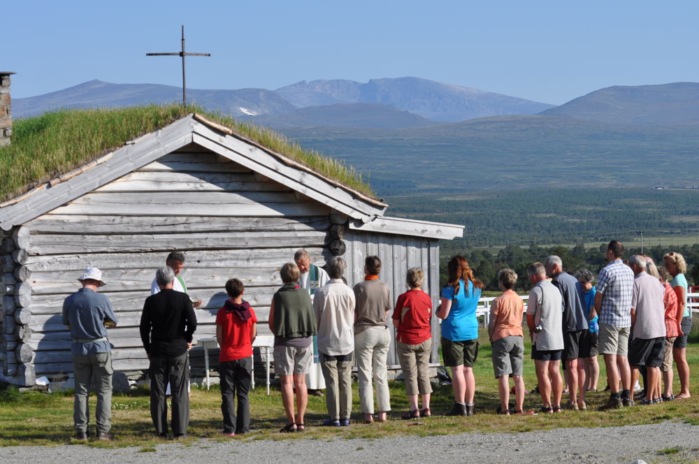 Fokstugu Fjellstue - En pilegrimsgruppe tar imot nattverd utenfor Guds Huset en stille sommermorgen. Foto: Laurits Fokstugu