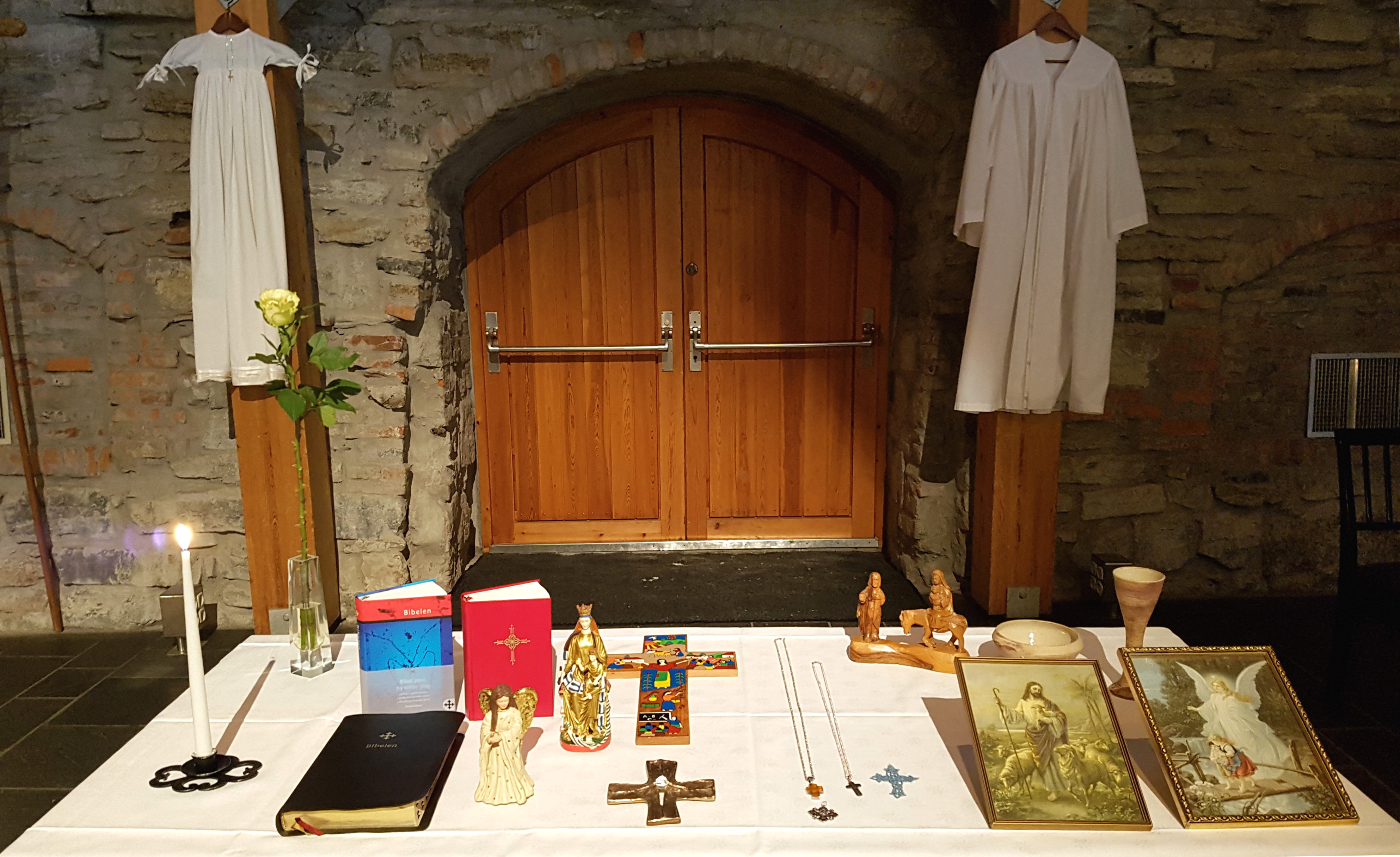En slik installasjon kan minner oss på de helt sentrale skattene vi forvalter som kirke. Bibel og salmebok, konfirmantkapper og andaktsbilder. Dåpskjoler og nattverdsutstyr.