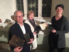 Det ble lånt inn bibler og salmebøker til utstillingen. Her viser Stein Westgaard og Jenny Åsbakk fram gamle bibler i familienes eie. Sokneprest Irmelin Grimstad Bonden til høyre på bildet. Foto: Berit Kristin Klevmoen