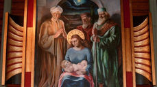 Utsnitt fra altertavla i Øvre Vang kirke. Altertavla er malt i 1933 av Ola Mathias Abrahamsson og forestiller kongenes tilbedelse av Jesusbarnet. Bildet er spesielt blant annet ved at bare Maria har stråleglans rundt hodet, men ikke Jesusbarnet. Det siste skyldes visstnok at kunstneren ble pålagt å gjøre om på bildet etter en klage.