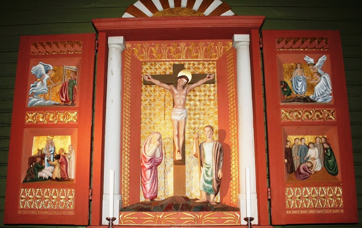 Altertavlen i Helgøya kirke er laget av Ragnhild Butenschøn. Motiv fra bebudelsen øverst til venstre.