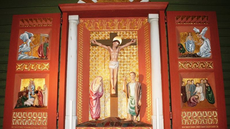 Altertavlen i Helgøya kirke er laget av Ragnhild Butenschøn. Motiv fra bebudelsen øverst til venstre.