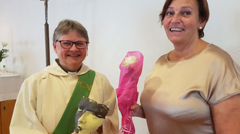 Fra markeringa av Berit Johansen (t.v) under en gudstjeneste på Godøya 16.august. Hun fikk gave og takk fra fellesrådet, ved Turid Urkedal Valderhaug, kirkeverge (t.h).  Gaven var ei «maske» laga av lokal kunstner Olav Leon Roald.