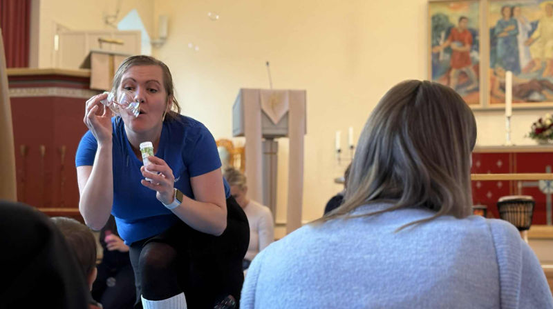 Randi Elisabeth Gullvåg blåser såpebobler til barna på babysangen i Heimdal kirke (Foto: Aud Kristin Saltvik Aasen)