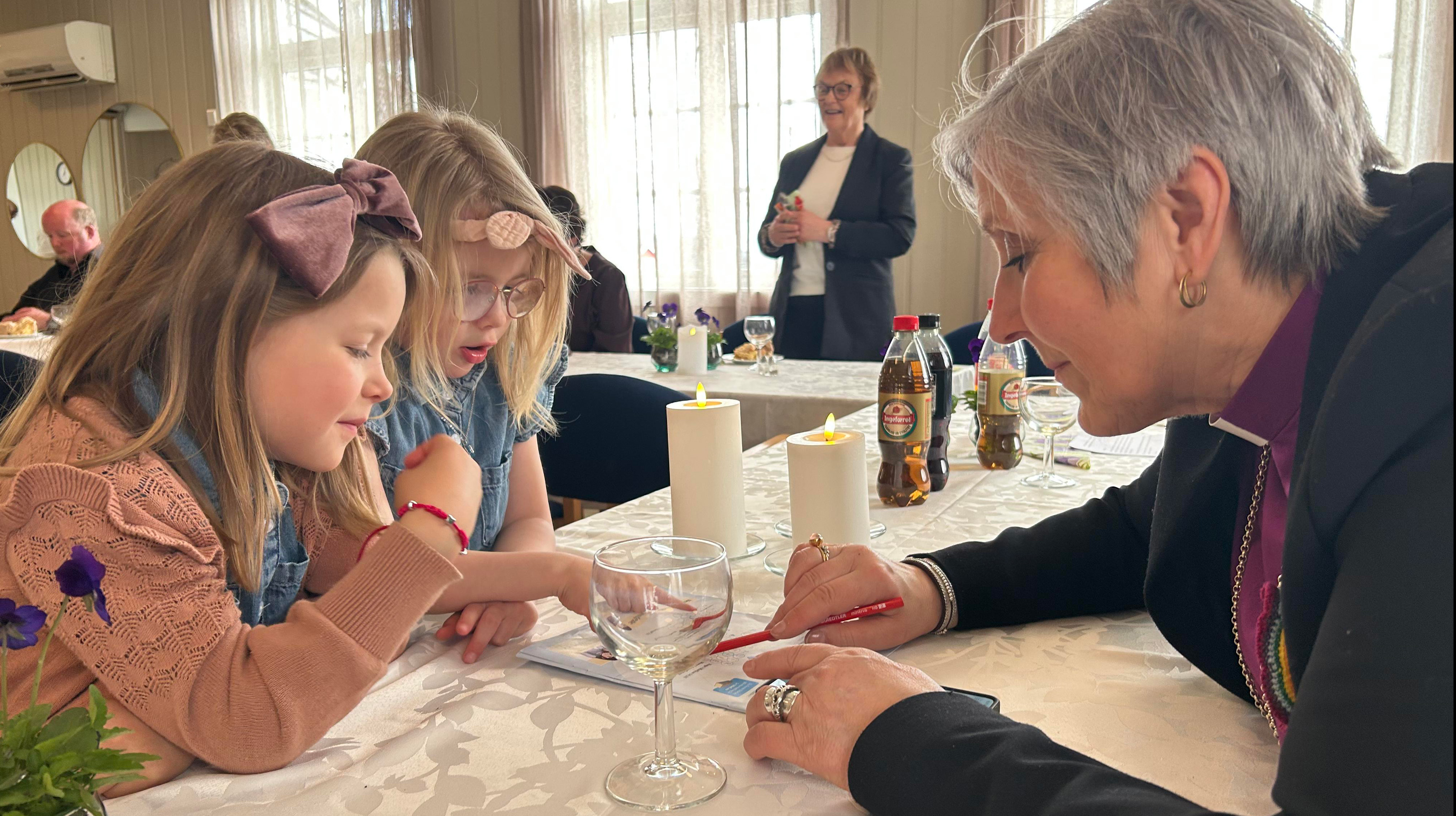 Fellesskap over bordet på siste visitasdag i Namdalseid. Biskop Herborg løser oppgaver sammen med Agnes og Frida Westerhus under kirkekaffen i Solhaug grendehus (Foto: Tina Møllersdatter Solbakken)