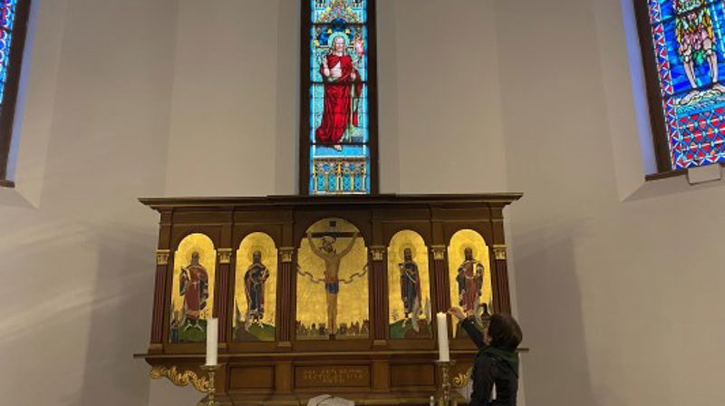 Prostiprest Hilde-Anette Løvenskiold Grüner tenner et lys før pilegrimene kommer.