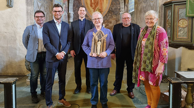 Arnhild Brustad er årets vinner av Nidarosen 2021, for sitt arbeid med Åpen kirke på Stiklestad. Under prisutdelingen i Stiklestad kirke, var det mange som ville gratulere. Fra venstre: Arnstein Indahl, Stiklestad Nasjonale Kultursenter, ordfører i Verdal Pål Sverre Fikse, sokneprest Gaute Aune Aurdal, prisvinner Arnhild Brustad, leder i Stiklkestad sokneråd Thor Bertil Granum og leder for Nidarosen-juryen Margit Sødal. (Foto: Birgitte Svegaard Dillan)