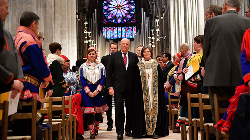 Kong Harald ankommer jubileumsgudstjenesten i Nidarosdomen, sammen med leder i samisk kirkeråd Sara Ellen Anne Eira og preses Helga Haugland Byfuglien. Foto: Ole Martin Wold / NTB scanpix.