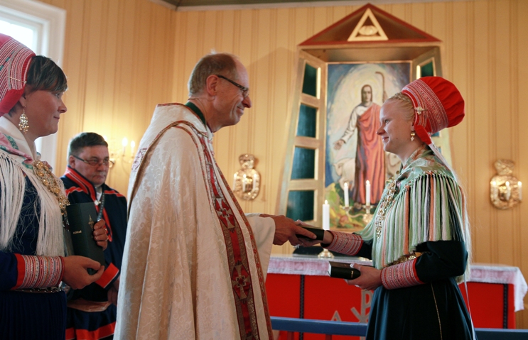 Elle Karen Inga Skum overrekker Bibelen til biskop Olav Øygard . Foto: Johan Mathis Gaup