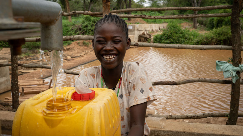 Før måtte Tsion (12) og Gaba (13) grave med bare hendene i sanden i en uttørket elv for å finne vann – som var skittent. Men nå har livet endret seg for de to jentene og resten av landsbyen: Med støtte fra Kirkens Nødhjelp har de fått tilgang til rent, rennende vann. Foto: Håvard Bjelland / Kirkens Nødhjelp