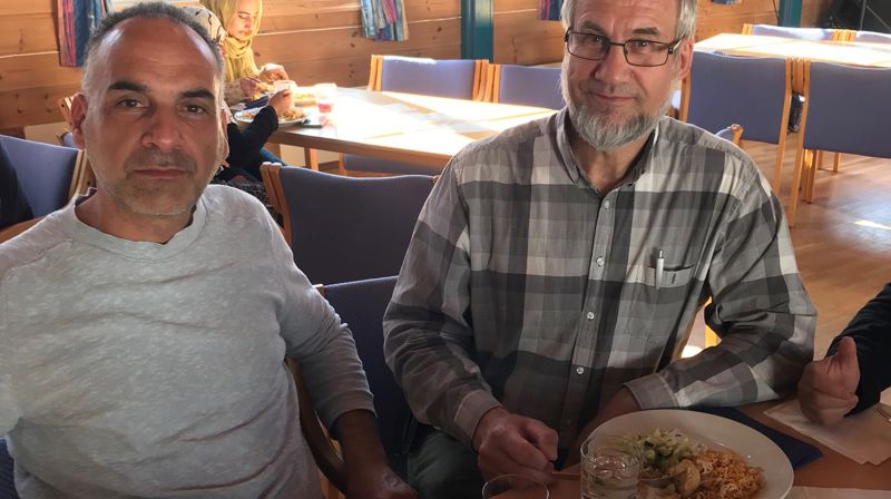 Fra en samling i mai hvor en syrisk familie hadde laget middagen som ble servert. Her sitter faren i familien sammen med diakon Tjøstolf Vittersø. Foto: AOT