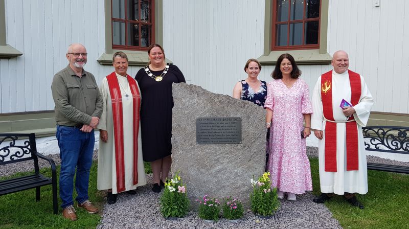 Minnestein ved Åsnes kirke er avduket. På bilde fra venstre: Tord Langmoen, Trine Færevåg, Kari Heggelund, Ann Kristin Botten Øwre, Nina Aaser Damhaug og Runar H. Olsen. Foto: Anne Bråten Edvardsen.