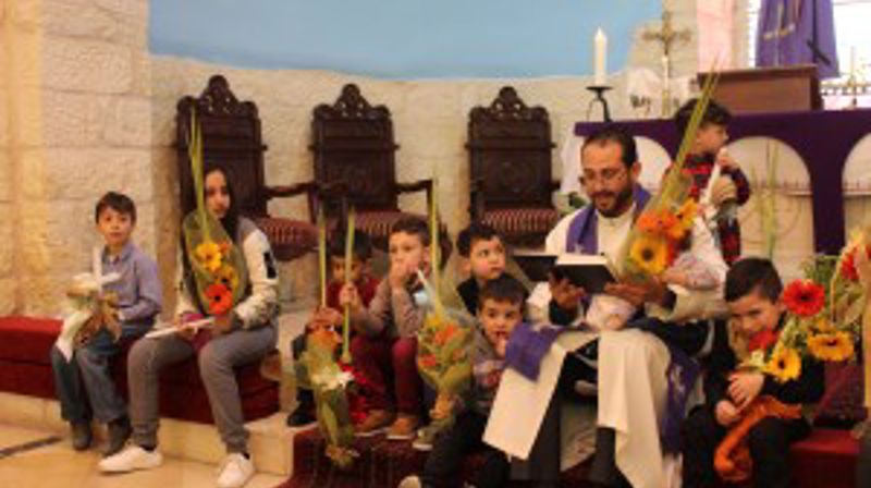 Prest og barn i kirken i Beit Jala