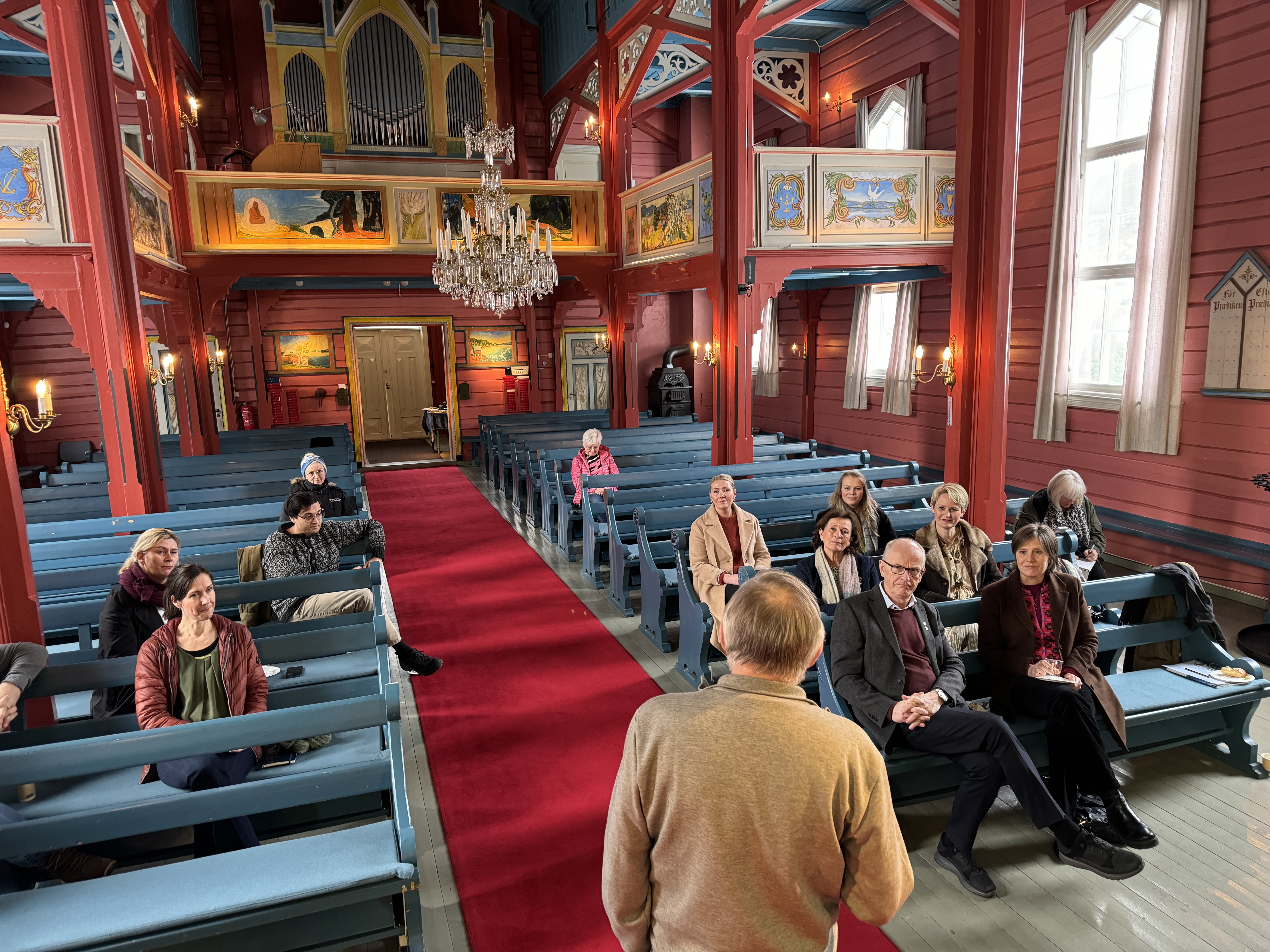 Frank Tangen forteller statsråd Toppe og følget om Holmsbu kirkes historie, utsmykning og tilknytning til kunstnerkolonien i Holmsbu. Foto: Asker kirkelige fellesråd