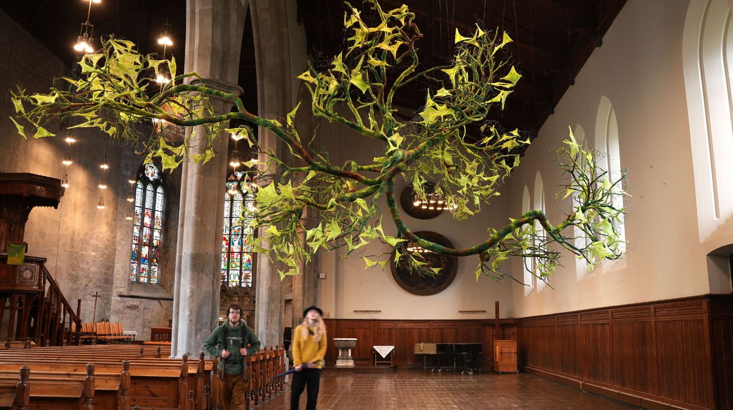 Linda Øgaards kunstinstallasjon svever i Bergen domkirke. Her er noen turister innom når kirken var åpen.