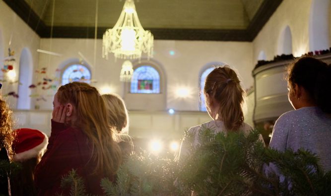 Deltagere i barnekor sett bakfra på konsert i Nykirken.