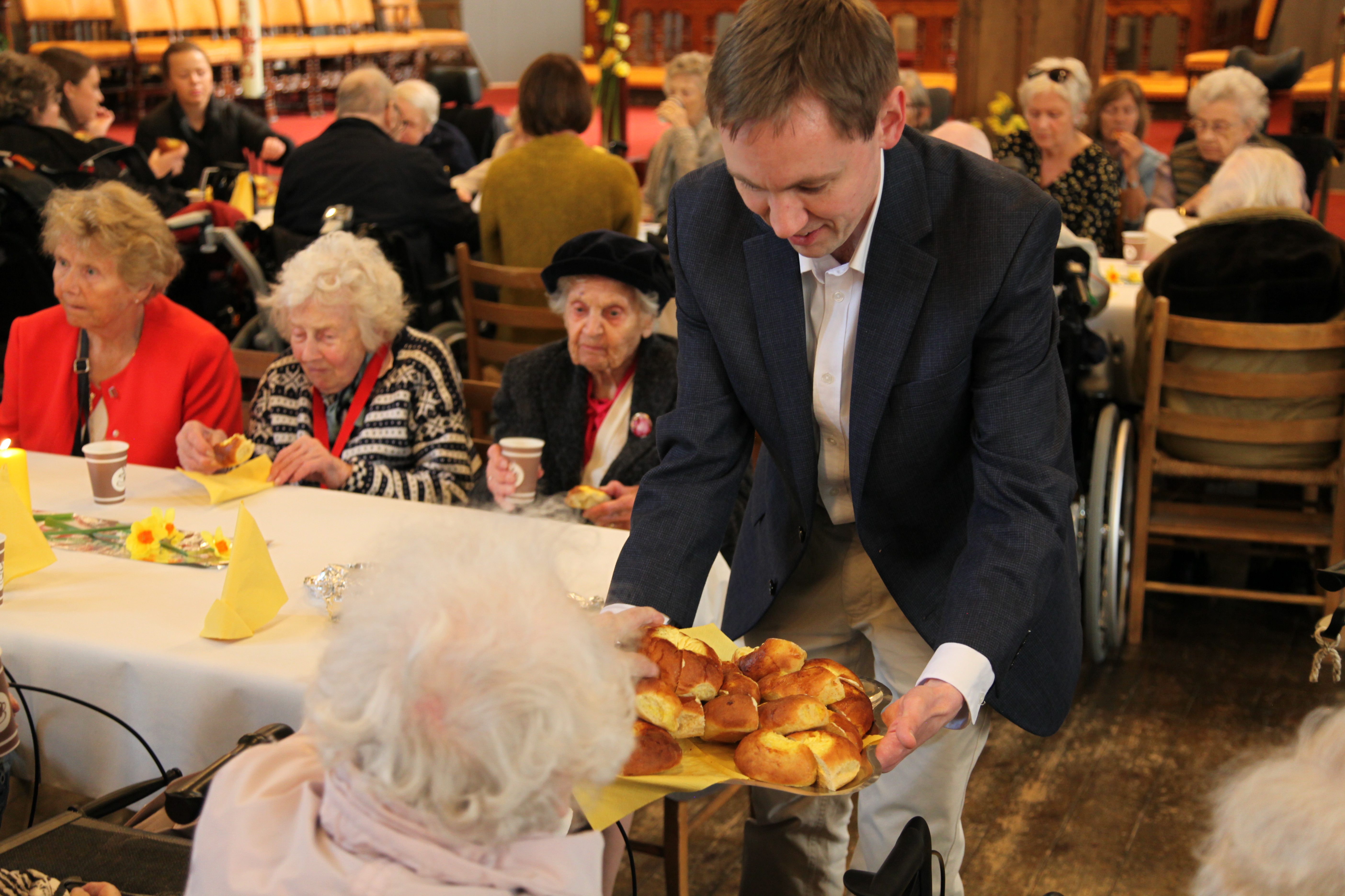 Domkantor Sigurd Melvær Øgaard serverer påskeboller under påskekonserten for eldre i Bergen domkirke. 