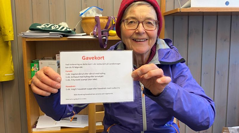 En av Misjonsutvalgets grand old ladies, Mette Waaler, holder frem en av de mange gevinstene MIsjonsutvalget har samlet inn til basar.