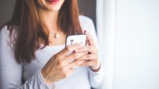 Foto: Karolina Grabowska fra Pixabay. Kvinne holder og ser på skjermen på telefonen sin.