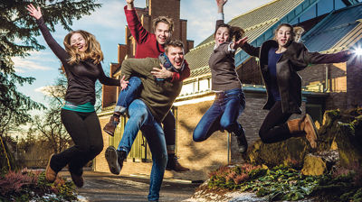 Illustrasjonsbilde. Bildet viser en menighetspedagog i samspill med glade og fornøyde konfirmanter.