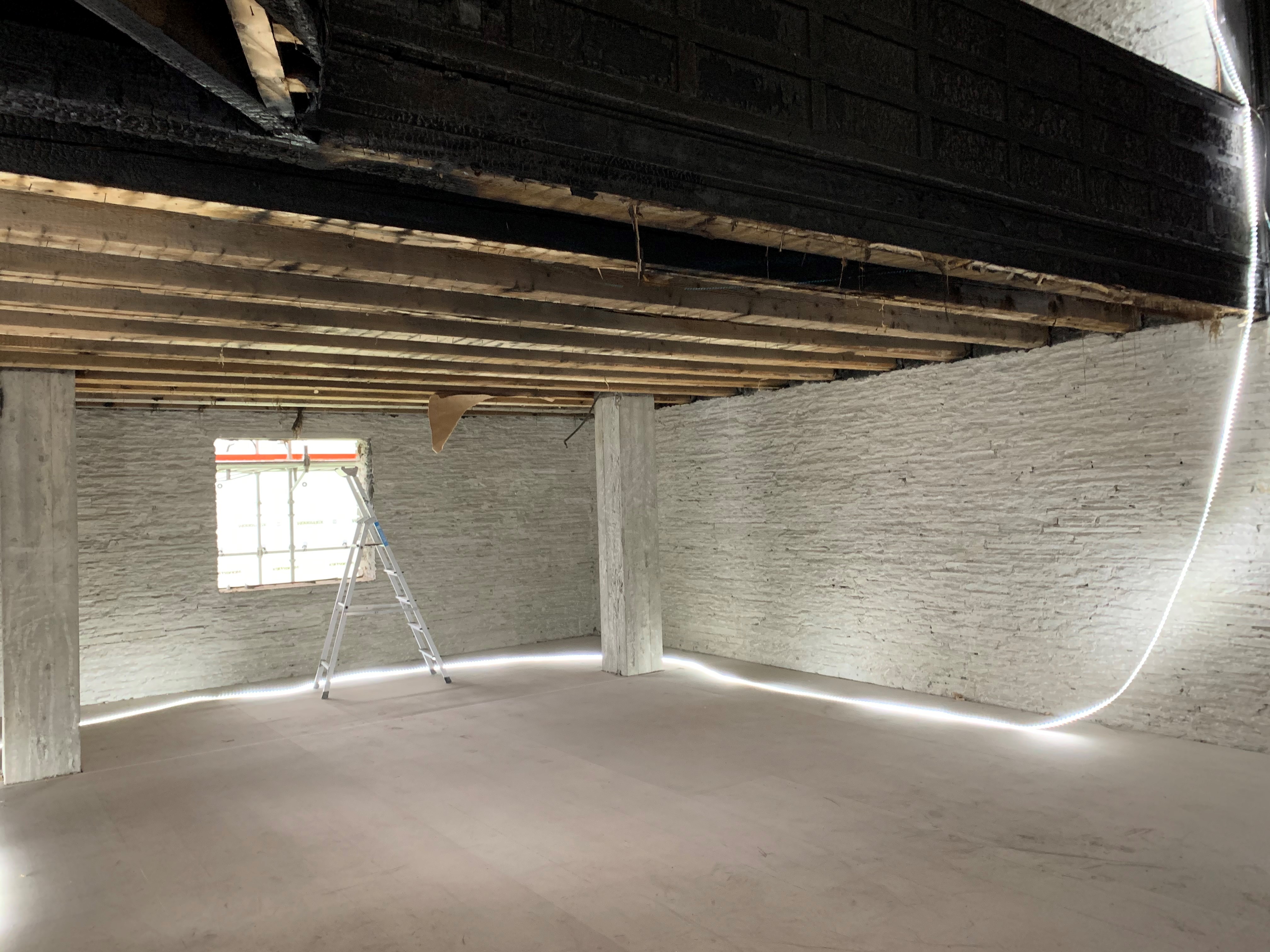 I kyrkjerommet er murpuss og treverk fjerna og det er lagt på midlertidig golvdet er 