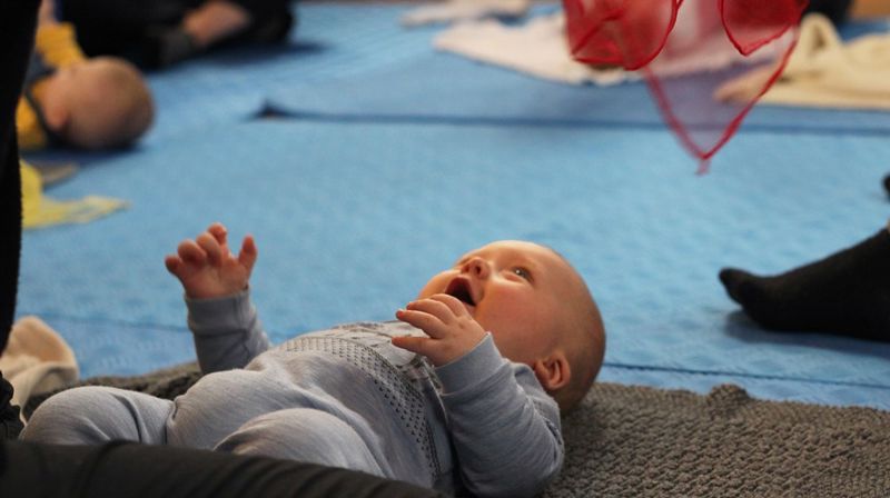 Barn og voksne i ring som leker