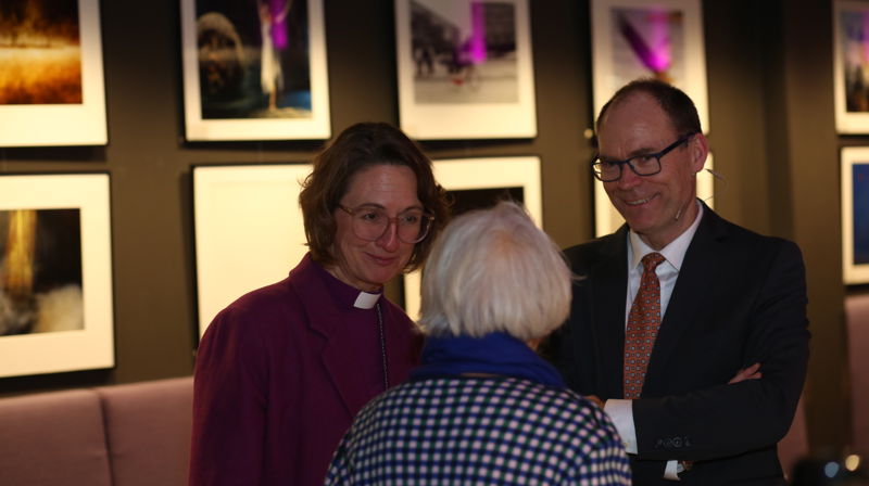 Biskop Kari og kirkeverge Per Ørjan i hyggelig samtale med en person fra menigheten under høstfesten.