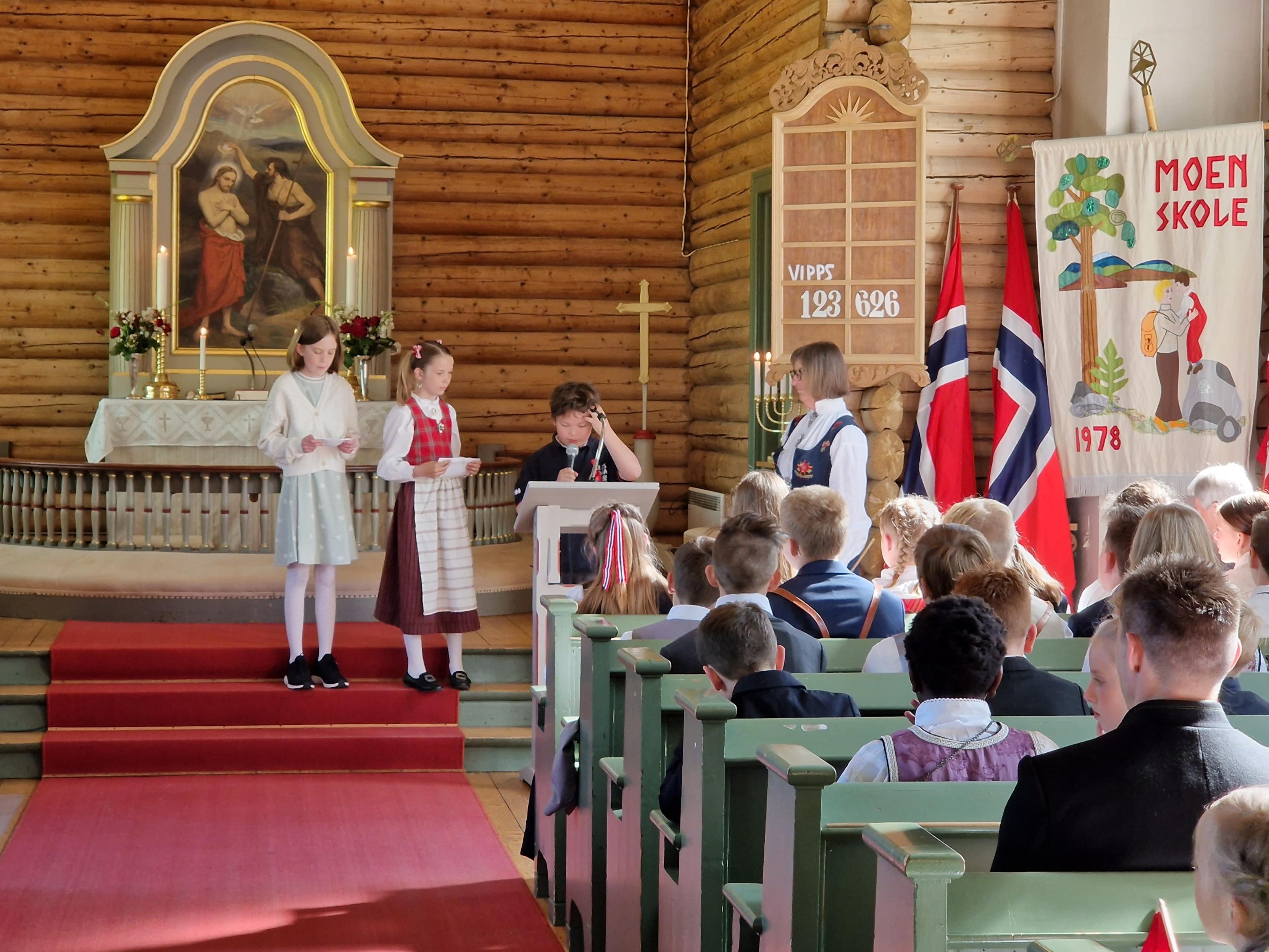 Elever fra Moen skole leser i familiegudstjenesten i Moen kirke 17. mai 2022 (foto: Jan Myrvold, Kirken i Gran).