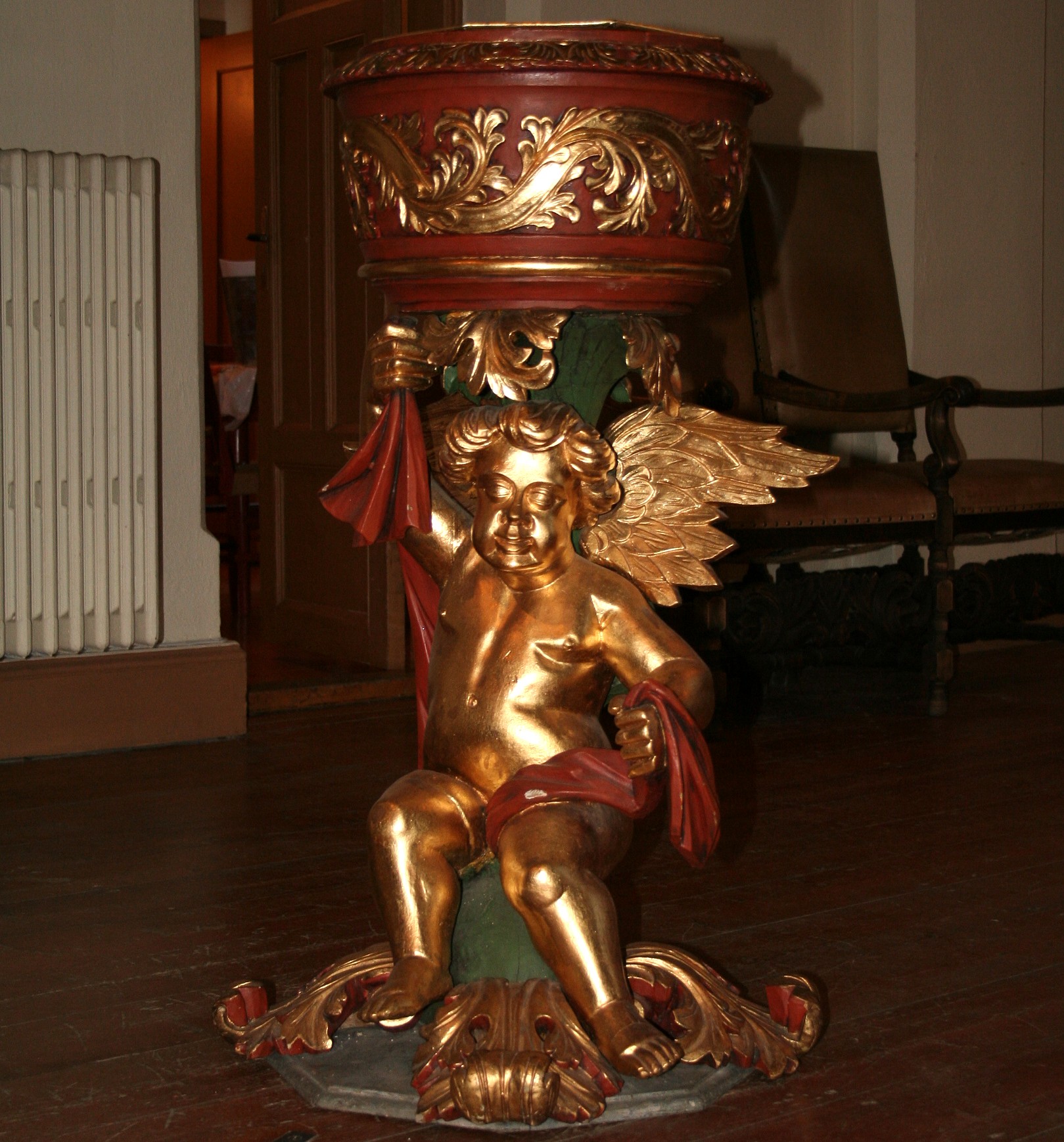 Døpefonten i Tingelstad kirke, med den flott utskårne engelen på foten, kommer opprinnelig fra stavkirka på Grinaker som ble tatt ut av bruk i 1866. Foto: Kirken i Gran. 