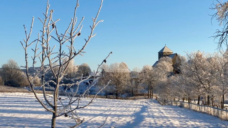 Nikolaikirken sett fra Pilgutua en novemberdag med nysnø (foto: Therese Wagle Bazard 2024).