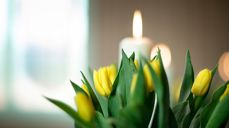 Påskestemning med gule tulipanblomster foran hvitt stearinlys. Står på alteret i Fenstad kirke. Foto: Bo Mathise