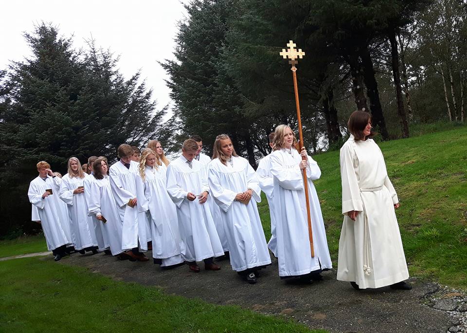 Menighetspedagog Ingunn Bergsager Våge leder prosesjonen inn til konfirmasjon i Rossabø kirke.