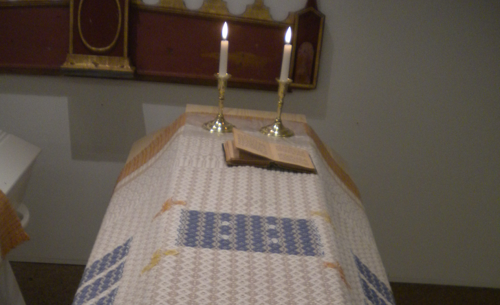 Kiste med kisteteppe og lys