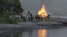 Bilde frå sommarleir 2022, båltenning på svaberg med deltakarar rundt bålet. Foto Karoline Thyri.