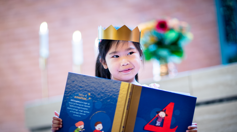 Fireåring med Min kirkebok. Foto: Bo Mathisen