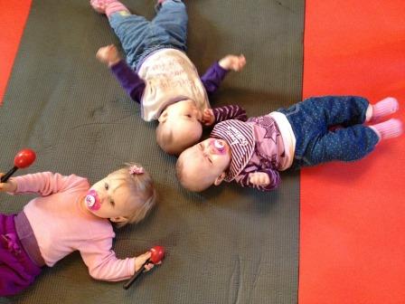 Tre babyer på matte på gulvet