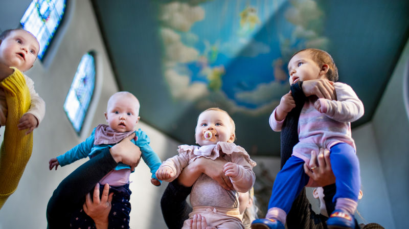 Babyer løftes opp i en kirke. Foto: Bo Mathisen