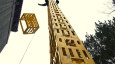 Bilde av en høy stabel med bruskasser, og en person på toppen av bruskassene.