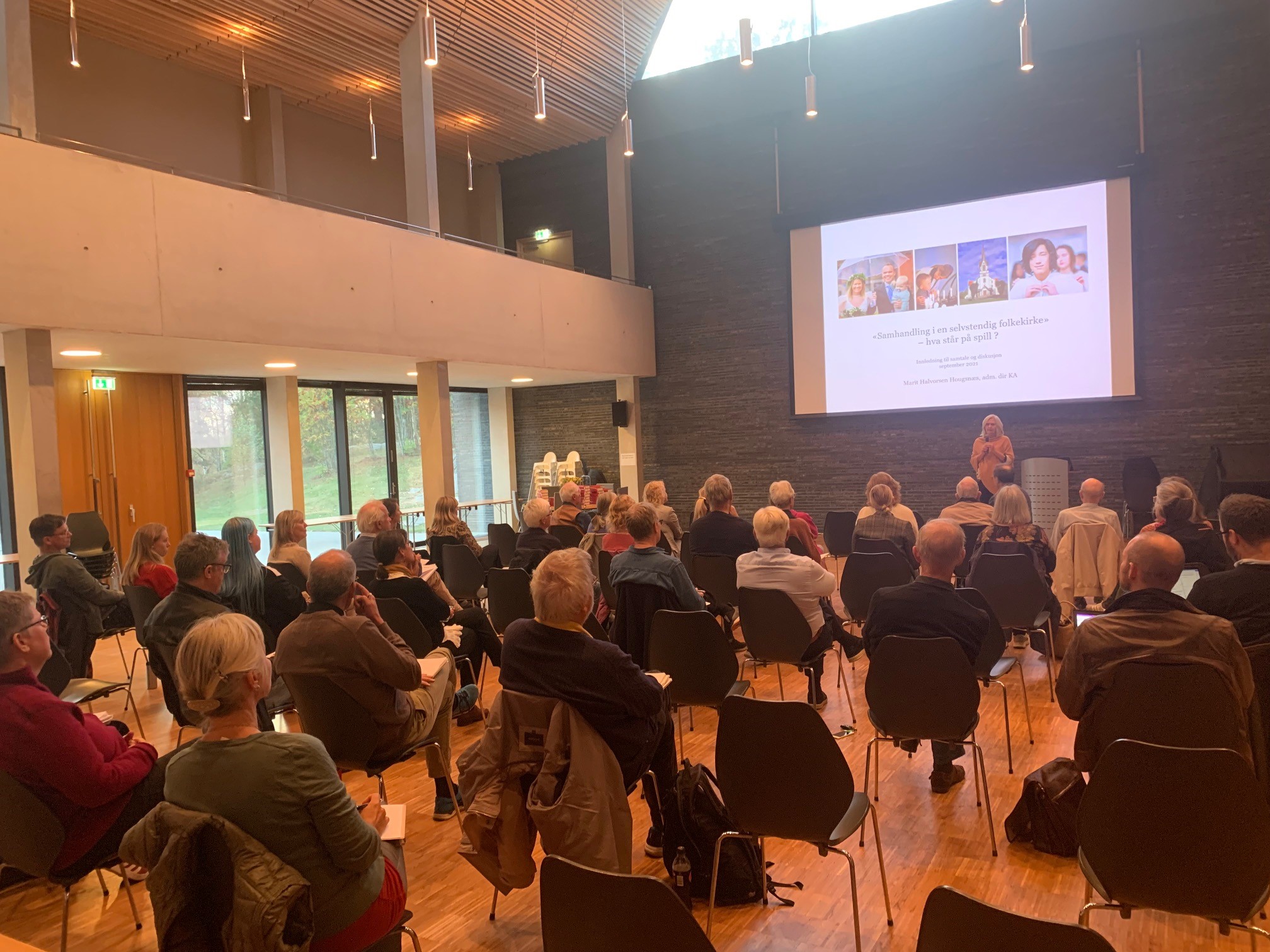 Menighetsrådsmedlemmer fra Oslo lytter til KA-direktør Marit Halvorsen Hougsnæs som foredrar om kirkelig organisering i Bøler kirke.